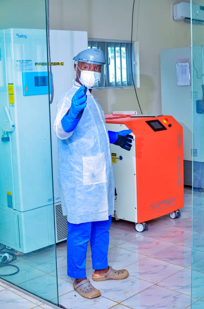 Laboratory scientist in PPE beside ultra-low temperature freezers